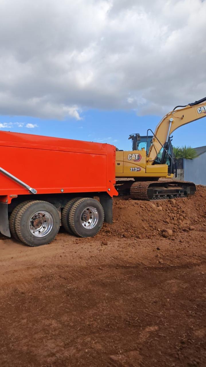Excavadora CAT y camión de volteo rojo en obra