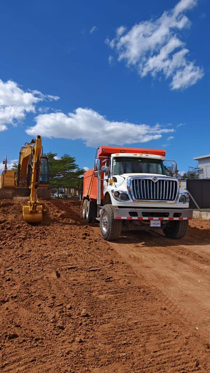 Camión y excavadora sobre terreno de trabajo