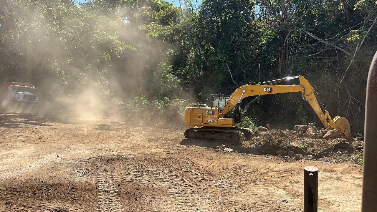 Excavadora CAT realizando movimiento de tierra en camino